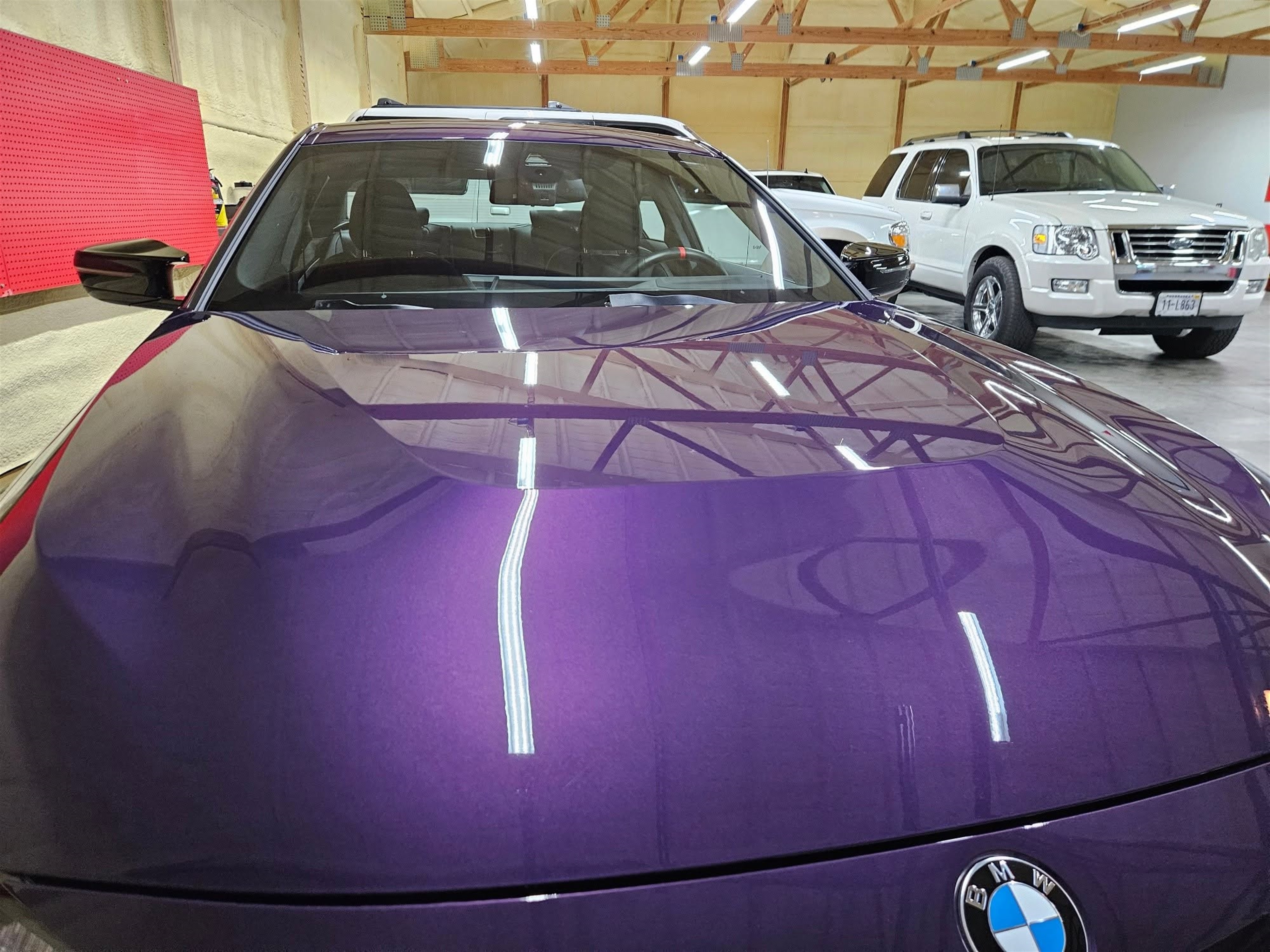 BMW hood reflecting overhead shop lights